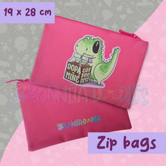Pink zip pouch with cartoon green dinosaur and badge-style graphic, zipper pull